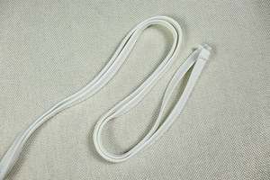 Detail of white fabric piping and fine stitching on a halter neck fashion outfit