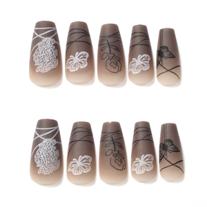 Detail of matte gradient coffin fake nails with white lace flowers and butterfly patterns