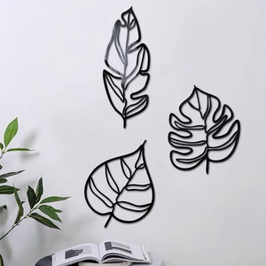 Vue détaillée de trois décorations murales 3D en métal noir en forme de feuilles