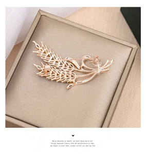 Detailed close-up of wheat brooch with sparkling zircons and a small pearl accent