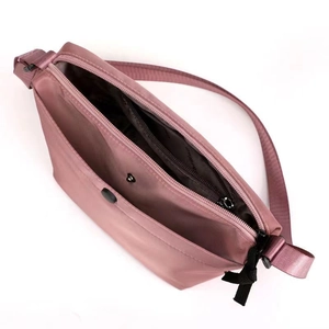 Pink nylon dumpling crossbody bag for women with adjustable strap and open main zipper