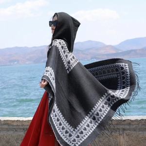 Cape à capuche de style ethnique avec motifs de cœur et franges portée au bord d'un lac