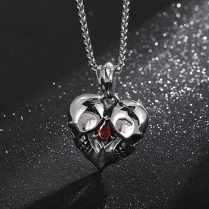 Detail of gothic heart skull pendant with a red water-drop stone and silver chain