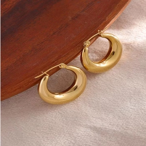 Vintage 18K gold-plated stainless steel hollow hoop earrings on a textured tray