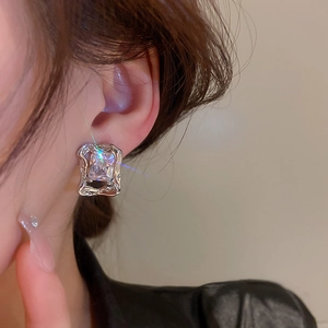 Close-up of silver multilayer hoop earring with square zircon on model's ear