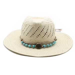 Ethnic straw jazz hat with turquoise beads and sun metal charm on white background