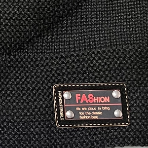 Black knit beanie with fashion patch and silver rivets for winter windproof warmth
