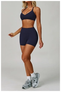 Deep blue yoga set detail showing V-neck sports bra and high-waist biker shorts