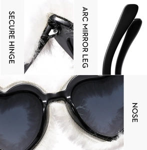 Detail view of heart sunglasses showing secure hinge, arc mirror legs, and soft nose pads
