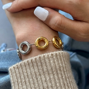 Detailed shot of two-tone gold and silver circular link bracelet on woman's wrist