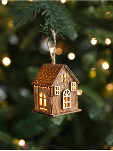 Dettaglio di un ornamento a casetta in legno illuminato con LED per l'albero di Natale