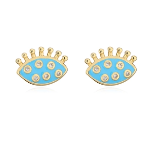 Primer plano de pendientes de ojo turco bañados en oro de 18K con esmalte azul y circón