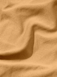 Close-up of premium amber orange pique knit fabric texture on men's athletic jogger pants