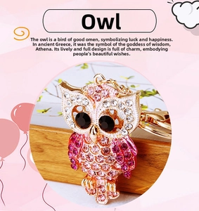 Macro shot of owl keychain pendant with pink and white rhinestones on gold metal base