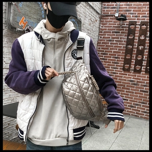 Detail of silver quilted belt bag with woven strap worn as a stylish crossbody chest bag