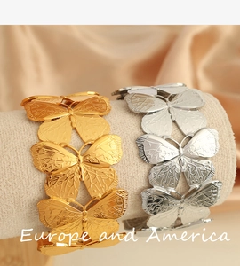 Detail of 18K gold plated butterfly open cuff bracelet with intricate textured wings