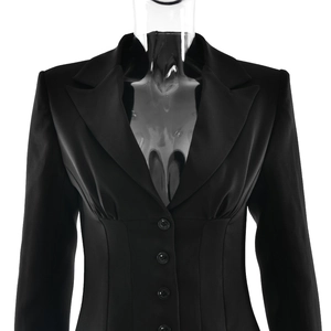 Détail du décolleté en V et des boutons à simple boutonnage sur un blazer noir cintré