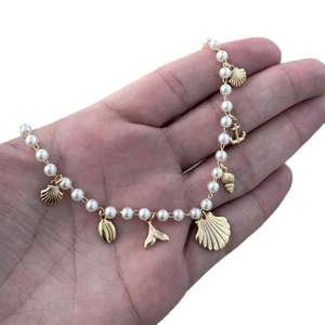 Nautical theme necklace with white pearls and gold shell, anchor, and fishtail charms