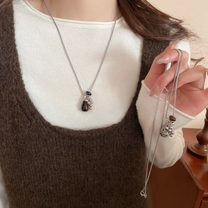 Detailed view of silver necklace featuring tiger eye bead and leopard jasper stone pendant