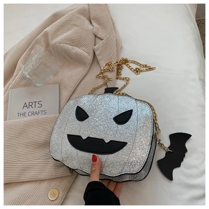 Detail of silver sequined pumpkin crossbody bag with black face and golden chain strap