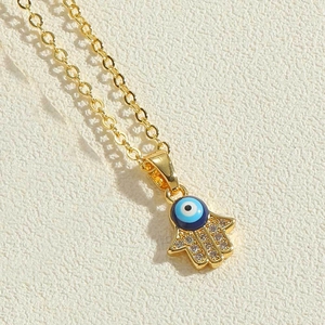 Makroaufnahme von Hamsa-Hand-Anhänger mit blauem Auge und Pavé-Fassung aus Zirkonias