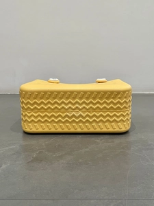 Close-up of yellow EVA beach bag showing wavy texture and white decorative fasteners