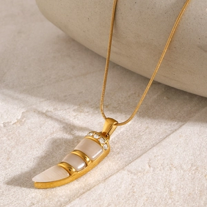 Detail of 18k gold plated chili pendant with white cat-eye stone and crystal accents