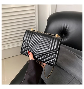 Close-up of black quilted leather shoulder bag featuring V-shaped and diamond patterns