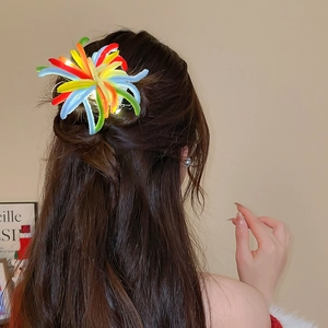 Detail showing glowing colorful plush hair clip with LED lights on model's hair