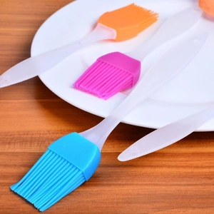 Three-piece colorful silicone basting brushes for BBQ and baking on a white plate