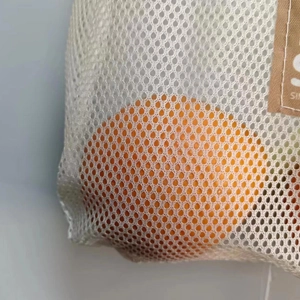 Macro shot of breathable beige mesh storage bag showing detailed grid texture and orange