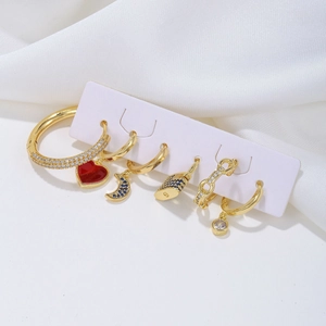 6-piece gold earring set with heart, moon, and lock charms on elegant silk background