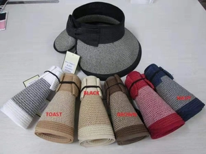 Flat lay detail showing a foldable straw beach hat in six colors with bow decorations