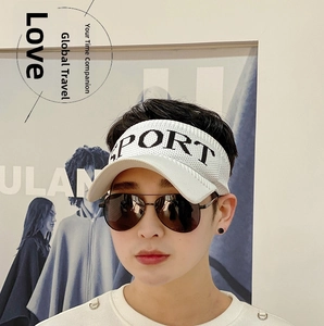 Close-up of a white sun visor with SPORT embroidery and breathable knit texture