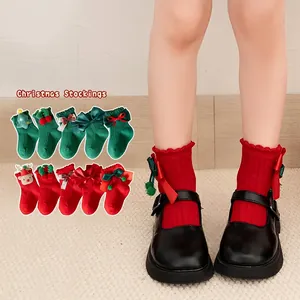 Festive red and green Christmas socks for kids with 3D bows and reindeer decorations
