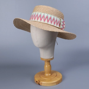 Bohemian raffia sun hat with colorful zigzag embroidery on a wooden mannequin base