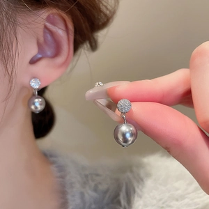 Détail de boucles d'oreilles en argent avec perles grises et pavé de zircons étincelants