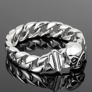Punk style silver stainless steel Cuban link bracelet with a detailed skull charm design