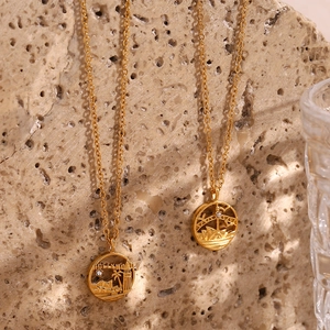 Macro shot of gold city-themed necklaces with Hollywood and Sydney landmark pendants