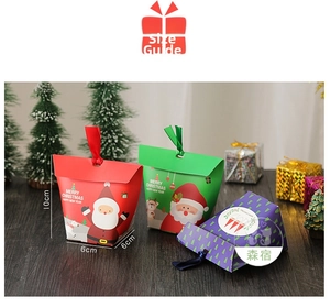 Detailed view of Christmas treat boxes with ribbon handles and festive cartoon patterns