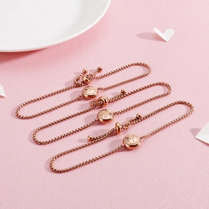 Detailed close-up of rose gold zodiac bracelets with Cancer and Virgo engravings