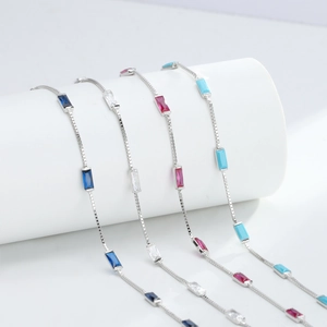 Detail showing elegant silver bracelets with rectangular blue, white, pink and green gemstones