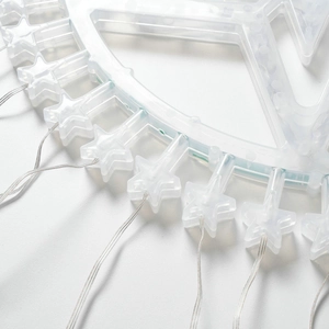Detail of star-shaped LED Christmas tree topper with white plastic frame and clear wiring