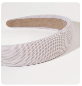 Close-up of white padded headband featuring fine shimmering texture and premium finish