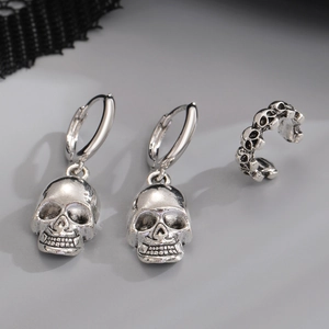 Detailed view of silver gothic skull earrings and ear cuff with oxidised finish details