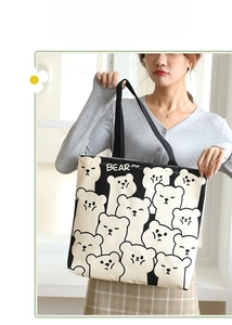 Detail of large canvas tote bag featuring black and white bear print and sturdy handles