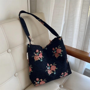 Detailed close-up of dark blue jacquard tote bag with vintage red floral patterns