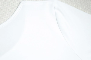 Détail du décolleté blanc à épaules dénudées avec couture surjetée professionnelle