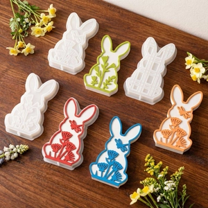 Detail of multi-pattern Easter bunny molds with floral and dragonfly textures on wood