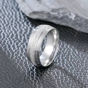 Detail of matte finish silver ring with polished edges on a luxury black leather texture